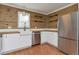 Bright kitchen with stainless steel refrigerator, a farmhouse sink, butcher block countertop, and natural wood plank walls at 5700 W 28Th Ave # 6, Wheat Ridge, CO 80214