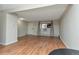 Open living room featuring laminate flooring, neutral walls, window AC unit, and curtains framing a large window at 5700 W 28Th Ave # 6, Wheat Ridge, CO 80214