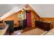 Charming attic space with wood paneling, unique decor, and natural light from a stained glass window at 7364 Rossman Gulch Rd, Morrison, CO 80465