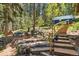Backyard entertaining area with stone accents, stairs, fire pit and lush green surroundings at 7364 Rossman Gulch Rd, Morrison, CO 80465