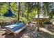 Serene backyard with mature trees, picnic table, stone accents, and views of the main house and storage shed at 7364 Rossman Gulch Rd, Morrison, CO 80465