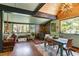 The dining area shows windows to the outdoors, wood burning stove, and comfortable seating at 7364 Rossman Gulch Rd, Morrison, CO 80465