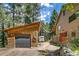 View of rustic cabin exterior with wood siding, stone foundation, and garage at 7364 Rossman Gulch Rd, Morrison, CO 80465
