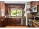 Well-lit kitchen featuring wood cabinets, stainless steel appliances, mosaic backsplash, and a bright window at 7364 Rossman Gulch Rd, Morrison, CO 80465