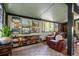 Cozy sitting room with beautiful artwork, a comfortable leather chair, and ample shelving at 7364 Rossman Gulch Rd, Morrison, CO 80465