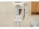 Bathroom featuring a pedestal sink, oval mirror, and a toilet at 15475 Andrews Dr # 314, Denver, CO 80239