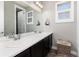 Bright bathroom with double sinks, ample counter space, and a woven laundry basket at 11582 Jimenez St, Parker, CO 80134