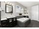 Modern bathroom featuring dual vanities, soaking tub, and stylish tile work at 11582 Jimenez St, Parker, CO 80134
