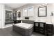 Modern bathroom with double vanities, a soaking tub, a walk-in shower, and elegant tile work at 11582 Jimenez St, Parker, CO 80134