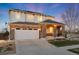 A charming two-story home with a stone-accented entrance and a wide driveway leading to an attached two-car garage at 11582 Jimenez St, Parker, CO 80134