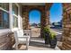 Inviting front porch with stone columns and an archway offering a relaxing outdoor space with seating and planters at 11582 Jimenez St, Parker, CO 80134