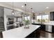 Open kitchen with a large white quartz island, dark cabinetry, and stainless steel appliances at 11582 Jimenez St, Parker, CO 80134