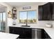 Contemporary kitchen with dark cabinets, white backsplash, and stainless-steel appliances, with a scenic backyard view at 11582 Jimenez St, Parker, CO 80134