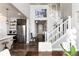 Open-concept living area with high ceilings, white staircase, hardwood floors, and modern decor at 11582 Jimenez St, Parker, CO 80134