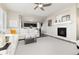 Bright living room featuring a white sofa, plush carpet, and a cozy fireplace with white stone surround at 11582 Jimenez St, Parker, CO 80134