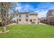 Spacious backyard with lush green lawn, patio dining set, grill, and two-story home exterior at 20534 E Union Cir, Aurora, CO 80015
