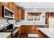 Well-lit kitchen featuring updated countertops, wooden cabinets, stainless steel appliances, and a sink at 20534 E Union Cir, Aurora, CO 80015