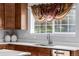 Bright kitchen with stainless steel sink, wood cabinets, and a window overlooking the backyard at 20534 E Union Cir, Aurora, CO 80015