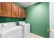 Efficient laundry room with wood cabinets, a washer, and a dryer, perfect for easy chores at 20534 E Union Cir, Aurora, CO 80015