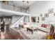 Bright living room featuring a vaulted ceiling, a staircase, and a large white sectional sofa at 20534 E Union Cir, Aurora, CO 80015
