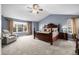 Main bedroom with large windows, vaulted ceilings, neutral carpet, and a wooden bedframe at 20534 E Union Cir, Aurora, CO 80015