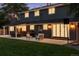 Exterior view of a home with a covered patio, outdoor seating and lush green lawn at twilight at 6279 E Princeton Ave, Cherry Hills Village, CO 80111