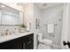 Modern bathroom with dark vanity, gold fixtures, and a white toilet at 6279 E Princeton Ave, Cherry Hills Village, CO 80111