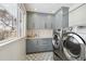 Laundry room with gray cabinets, hexagon tile, and new appliances at 6279 E Princeton Ave, Cherry Hills Village, CO 80111