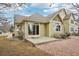 Back exterior of a tan house with a concrete patio, nice roof, and gravel at 616 Wild Ridge Cir, Lafayette, CO 80026