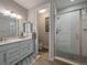 Bathroom with double sinks, decorative mirrors, tile floors and a glass shower at 2468 Channel Dr, Highlands Ranch, CO 80129
