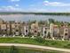 Contemporary townhomes lined up with green space and a tranquil lake backdrop at 2468 Channel Dr, Highlands Ranch, CO 80129