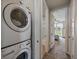Convenient laundry room with a stacked washer and dryer, plus a view into the primary bedroom at 2468 Channel Dr, Highlands Ranch, CO 80129