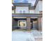 Two-story townhome with gray siding, brick accents, and a covered porch at 14948 E Belleview Ave, Aurora, CO 80015