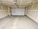 Attached garage with white automatic door and concrete floor at 14948 E Belleview Ave, Aurora, CO 80015