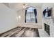 Bright room with a large window, ceiling fan, and adjacent brick fireplace at 4760 S Wadsworth Blvd # M302, Littleton, CO 80123