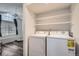 Convenient laundry area with modern washer and dryer units, plus built-in shelving for organized storage at 4760 S Wadsworth Blvd # M302, Littleton, CO 80123