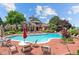 Community pool surrounded by lounge chairs, umbrellas, and mature trees for relaxing summer days at 4760 S Wadsworth Blvd # M302, Littleton, CO 80123