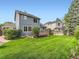Backyard showcasing lush green lawn, mature trees, and a wooden deck at 13472 Columbine Cir, Thornton, CO 80241