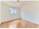Bright bedroom featuring hardwood floors, a ceiling fan, and natural light from the window at 13472 Columbine Cir, Thornton, CO 80241