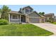 Charming home featuring a well-manicured lawn, covered porch, and two-car garage at 13472 Columbine Cir, Thornton, CO 80241