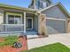 Charming home featuring a covered porch, a two-car garage, and professionaly designed landscaping at 13472 Columbine Cir, Thornton, CO 80241