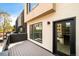 A modern home's back deck features a black door, windows, and grey wood flooring at 2738 N Clay St, Denver, CO 80211