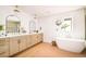Bright and airy bathroom with double vanity, freestanding tub, neutral color palette, and modern fixtures at 2738 N Clay St, Denver, CO 80211