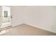 A blank room features a walk-out door, carpet flooring, and bright white walls at 2738 N Clay St, Denver, CO 80211
