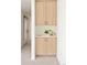 Close up of a modern hallway with a built-in storage cabinet featuring light wood doors and a white countertop at 2738 N Clay St, Denver, CO 80211
