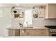 Close up of bright kitchen with white tile backsplash, stainless steel appliances, and open shelving at 2738 N Clay St, Denver, CO 80211