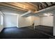 Unfinished basement featuring concrete ceiling with visible piping and black carpeted floor at 23955 Glenmoor Way, Parker, CO 80138