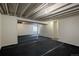Unfinished basement featuring concrete ceiling with visible piping and black carpeted floor at 23955 Glenmoor Way, Parker, CO 80138