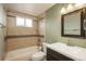 Neutral bathroom with decorative mirror and tile shower and bath combination at 23955 Glenmoor Way, Parker, CO 80138