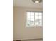 A neutral bedroom with a large window showing a view of neighborhood homes at 23955 Glenmoor Way, Parker, CO 80138